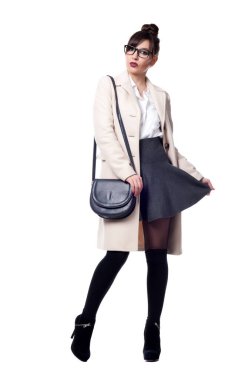 Güzel, seksi esmer kız beyaz bir arka planda poz veriyor.