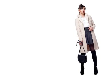 Güzel, seksi esmer kız beyaz bir arka planda poz veriyor.