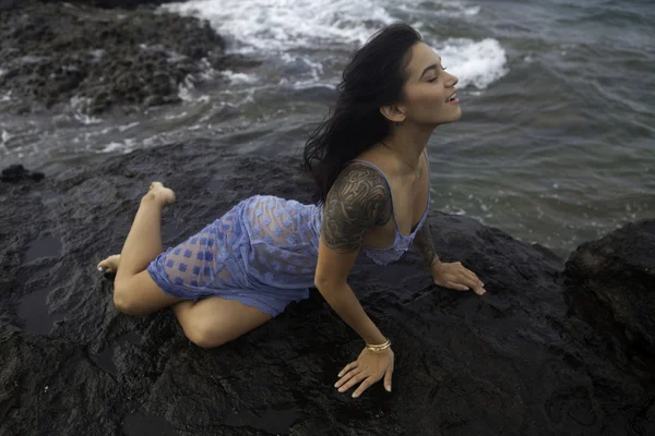 Girl on rocks by ocean — Stock Photo, Image