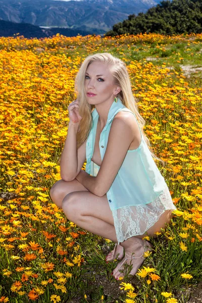 Belle blonde dans le champ de fleurs — Photo