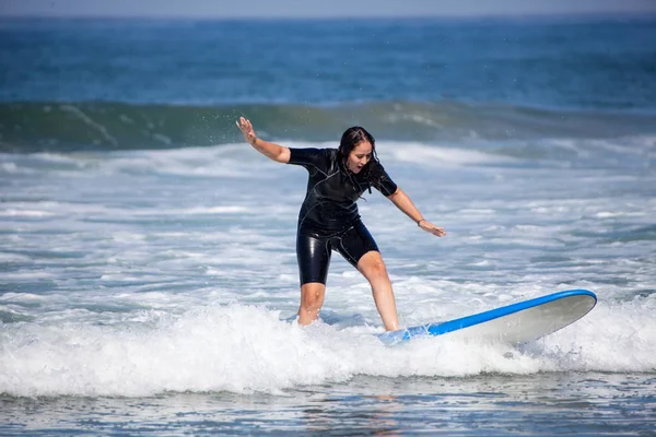 Mujer joven en su tabla de surf —  Fotos de Stock