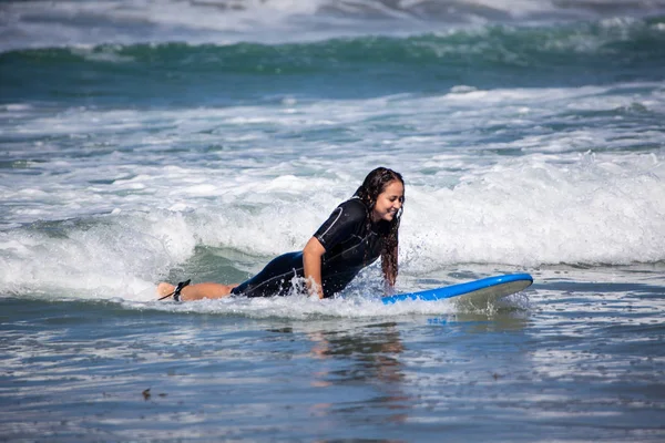 Mujer joven en su tabla de surf —  Fotos de Stock