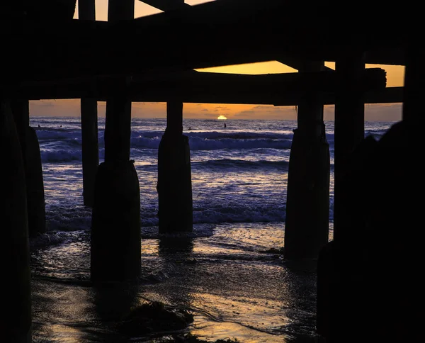 Zonsondergang onder een pier — Stockfoto