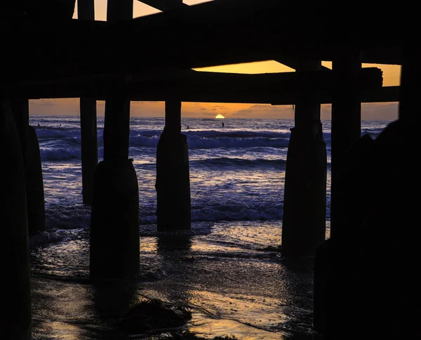 Puesta de sol bajo un muelle — Foto de Stock