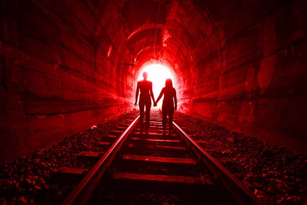 Couple in love walking together through a railway tunnel — Stock Photo, Image