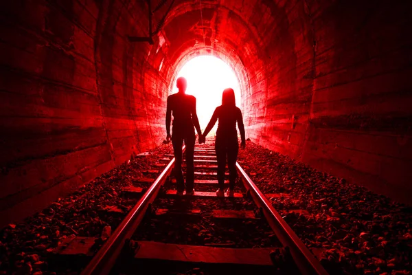 Couple in love walking together through a railway tunnel — Stock Photo, Image