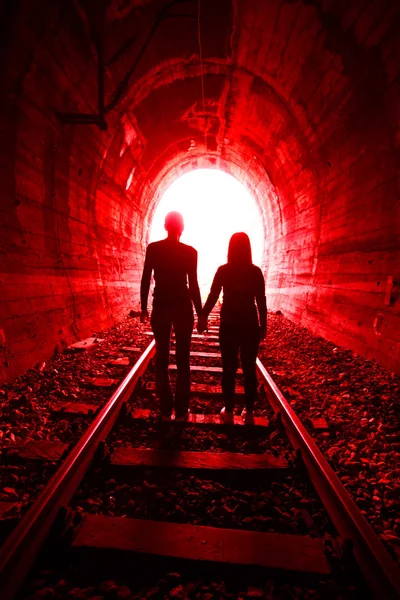 Casal apaixonado andando juntos através de um túnel ferroviário — Fotografia de Stock