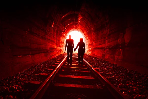 Couple in love walking together through a railway tunnel — Stock Photo, Image