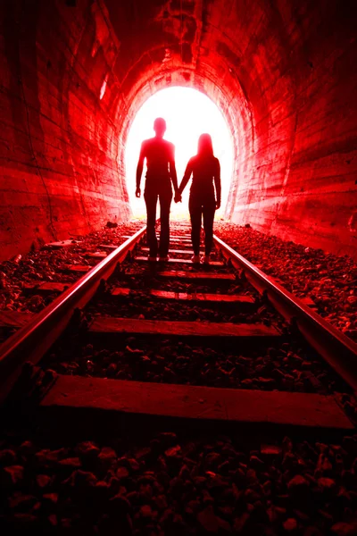 Couple in love walking together through a railway tunnel — Stock Photo, Image