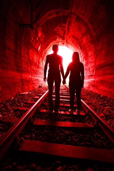 Pár szerelmes gyaloglás együtt egy vasúti alagúton keresztül — Stock Fotó
