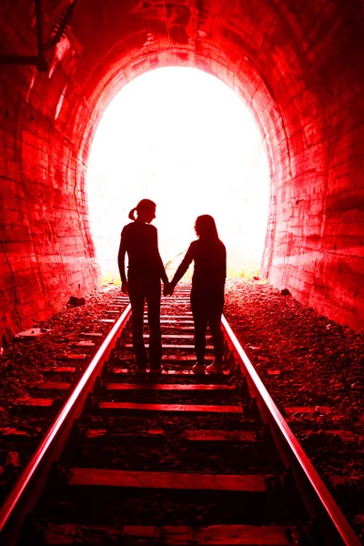 Casal apaixonado andando juntos através de um túnel ferroviário — Fotografia de Stock