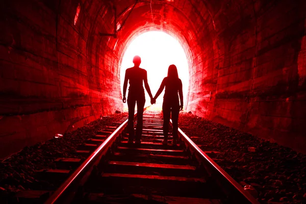 Couple in love walking together through a railway tunnel — Stock Photo, Image