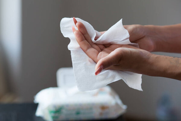 Woman cleaning hands with wet wipes