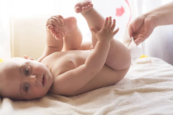 Mamma Rengör försiktigt babyhud med våtservetter — Stockfoto