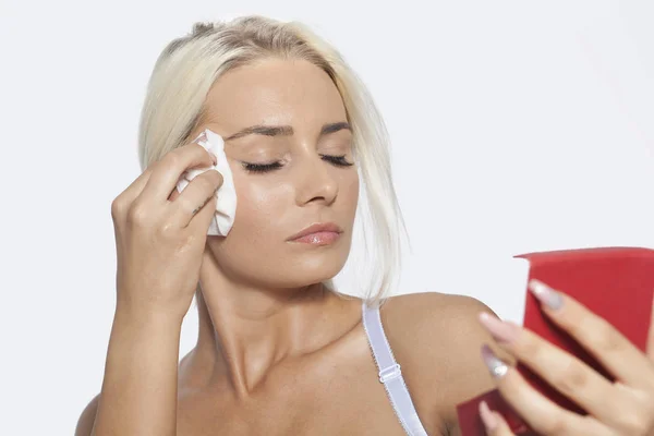 Wanita muda wajah bersih dengan tisu basah dan memegang cermin — Stok Foto