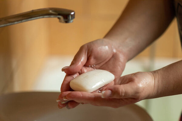 Influenza prevention: Cleaning hands with soap against disease infection versus flu or infulenza, background blurred