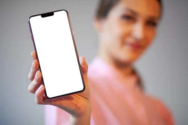 広告やアプリケーションのモックアップのための空白の白い画面と新しい近代的なスマートフォンを示す女性 — ストック写真