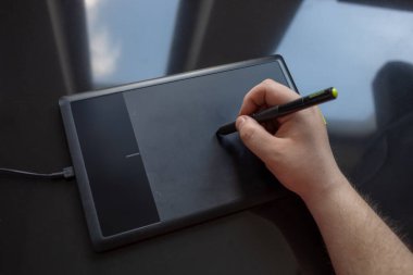 Grafik tablo ve kalem sanatçının elinde. Dijital Çizim ve Dijitalleştirme