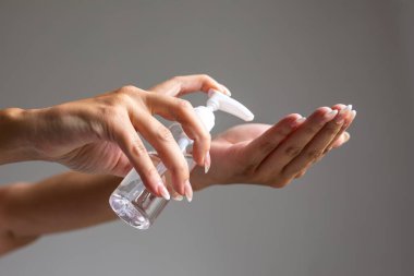 Küçük taşınabilir antibakteriyel el dezenfektanı kullanan kadın görüntüsünü kapat. Stok fotoğrafı