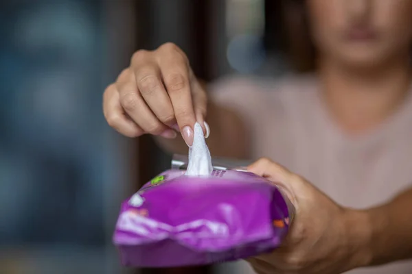 Young woman open package of antibacterial wet wipes to cleaning hands
