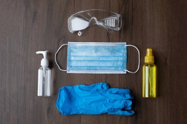 Corona covid virüsleri - chirurgical maske, eldivenler, bardaklar ve şişeler ve masada alkol ve sıvı sabun