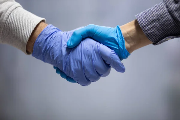 Händeschütteln Mit Blauen Schutzhandschuhen — Stockfoto