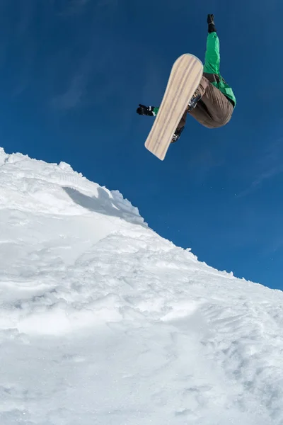 Snowboarder springt gegen blauen Himmel — Stockfoto