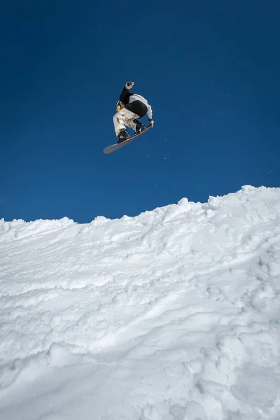 Mavi gökyüzüne atlayan snowboardcu — Stok fotoğraf