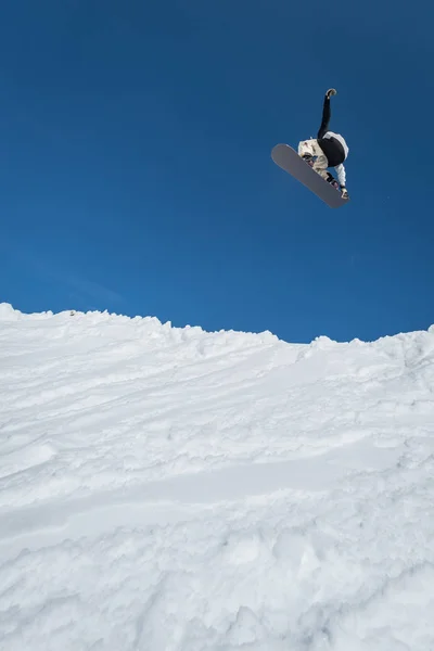 Snowboarder saltando contro il cielo blu — Foto Stock