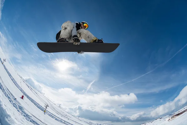 Snowboardåkare hoppar mot blå himmel — Stockfoto