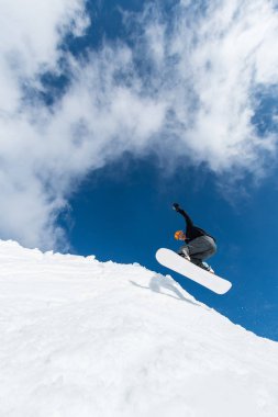 Mavi gökyüzüne atlayan snowboardcu