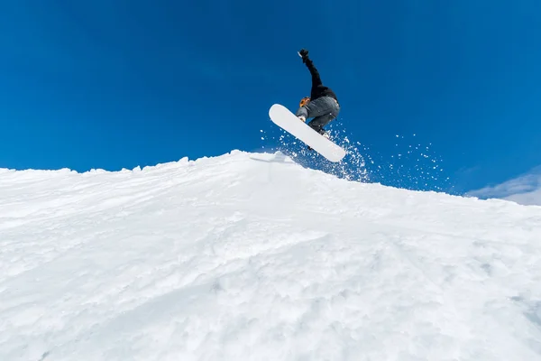 Snowboardista skákání proti modré obloze — Stock fotografie