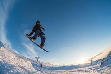 Mavi gökyüzüne atlayan snowboardcu