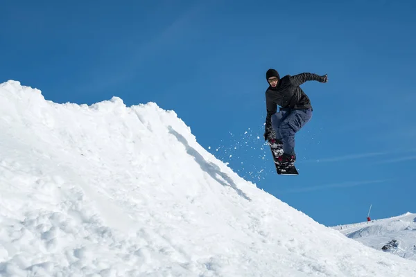 Snowboarder saltando contro il cielo blu — Foto Stock