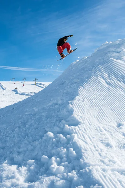 푸른 하늘을 향해 점프하는 스노보더 — 스톡 사진