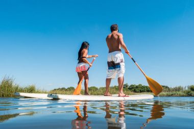 Erkek ve kadın paddleboarding kadar stand