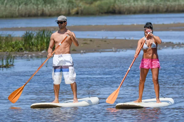 Erkek ve kadın paddleboarding kadar stand — Stok fotoğraf