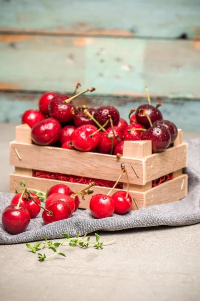 Cerises mûres rouges dans une petite boîte en bois — Photo