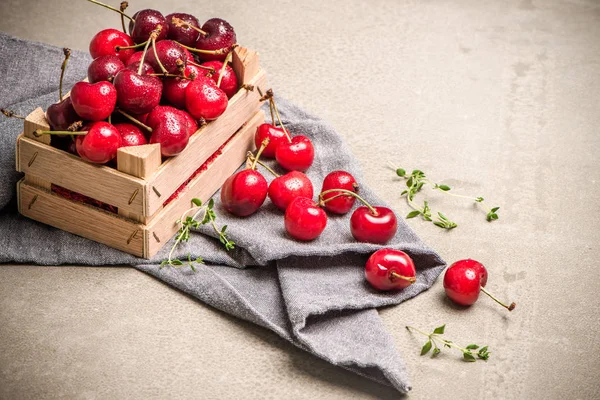 Punainen kypsä kirsikat pieni puinen laatikko — kuvapankkivalokuva