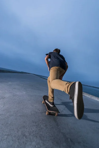 Skateboardista tlačí na betonovém chodníku — Stock fotografie