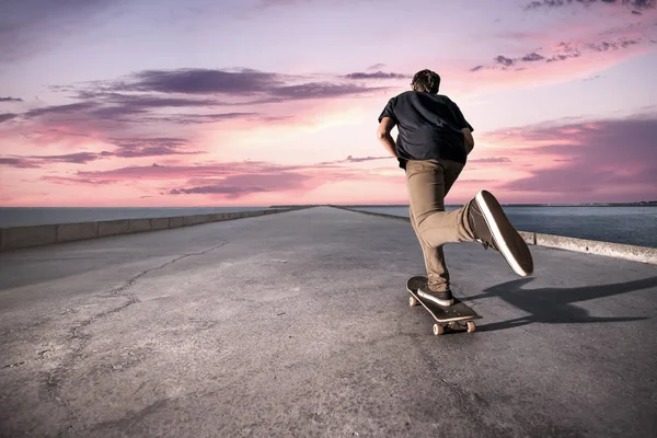 Skateboardista tlačí na betonovém chodníku — Stock fotografie