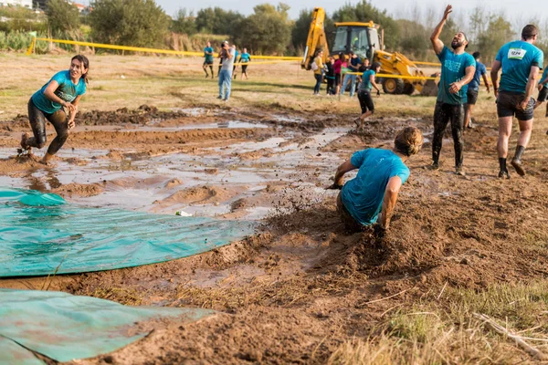 Atletas deslizándose hacia el barro y el agua —  Fotos de Stock