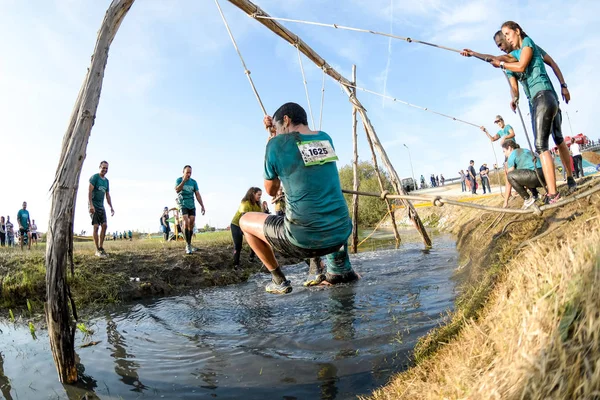 Gli atleti passano attraverso fango e acqua — Foto Stock