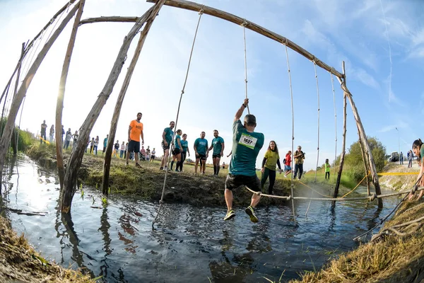 Los atletas pasan por el barro y el agua —  Fotos de Stock