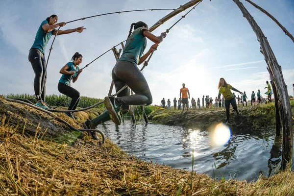 Idrettsutøvere går gjennom gjørme og vann – stockfoto