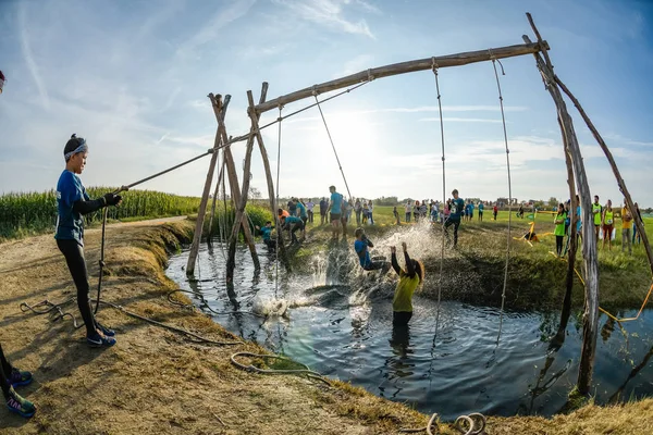 Los atletas pasan por el barro y el agua —  Fotos de Stock