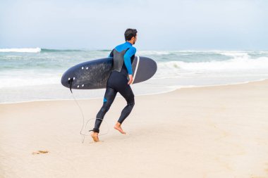 Wetsuit giyen genç erkek sörfçü