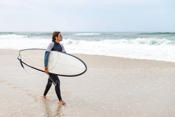 ウェット スーツを身に着けている若い女性サーファー — ストック写真