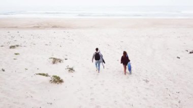 Genç çift dostu sörfçü plaja yürüme