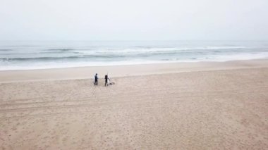 Dost sörfçü wetsuit giyen genç Çift